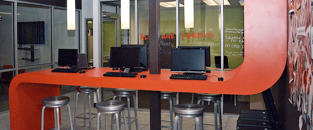 orange curved desk with computers