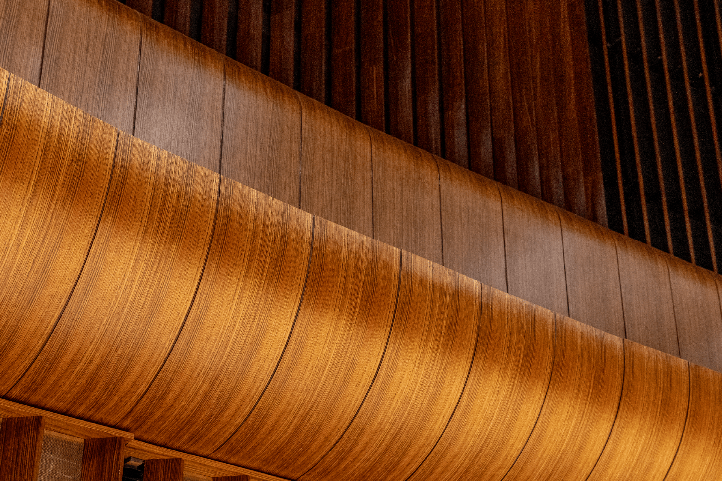 up close of a curved balcony finished in a rich wood veneer